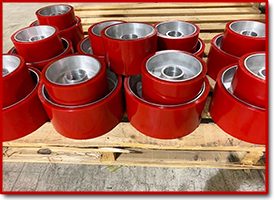 Red aluminum wheels of different sizes ready for shipping